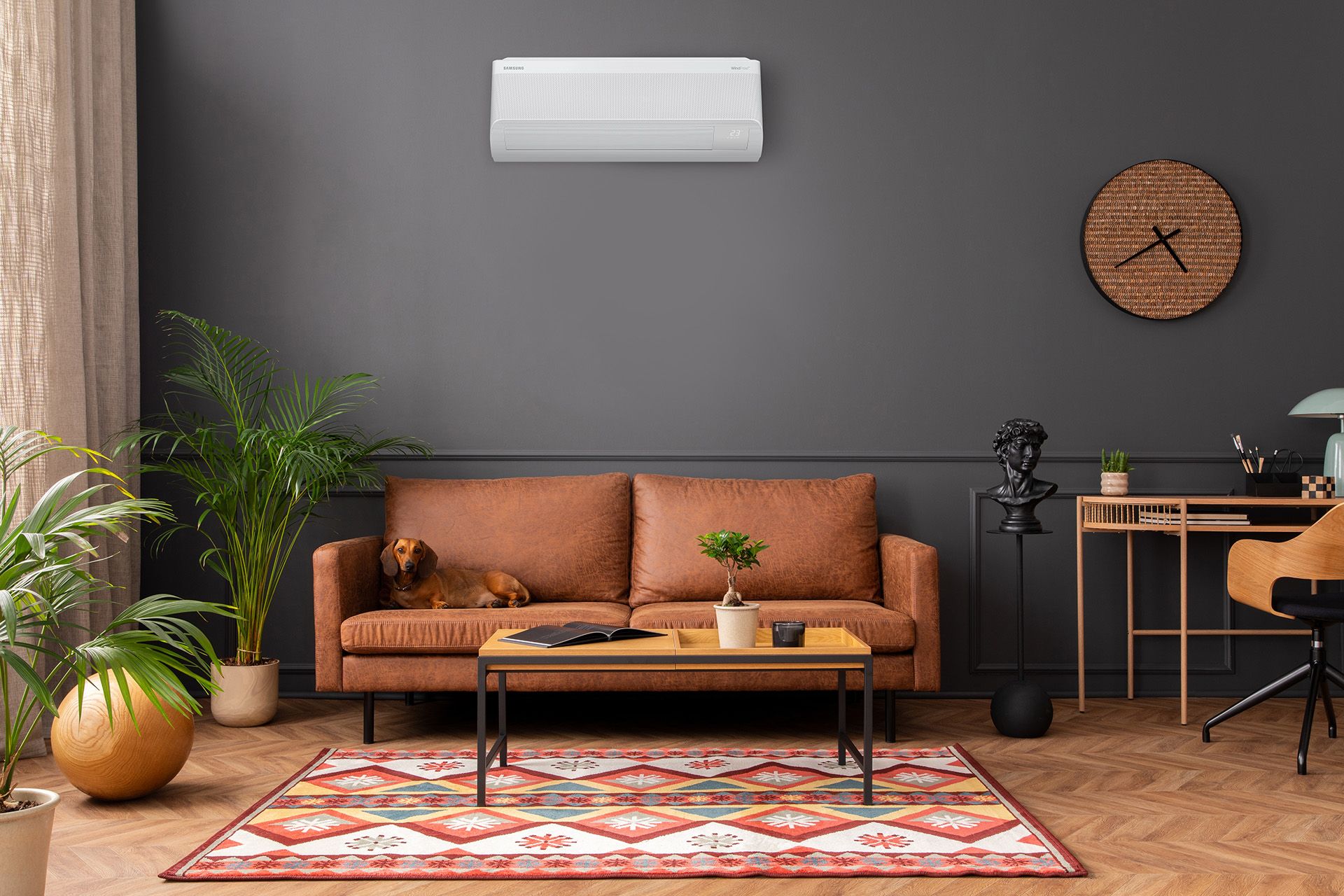 Woonkamer met een oranje bank en een Samsung airco aan de muur